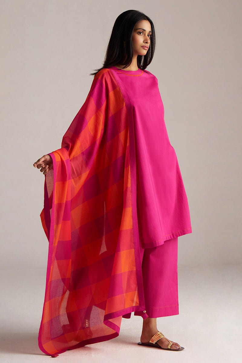 Woman wearing a bright pink outfit with a colorful dupatta on a plain background | Fuchsia Solid Kurta with Mul Mul Dupatta