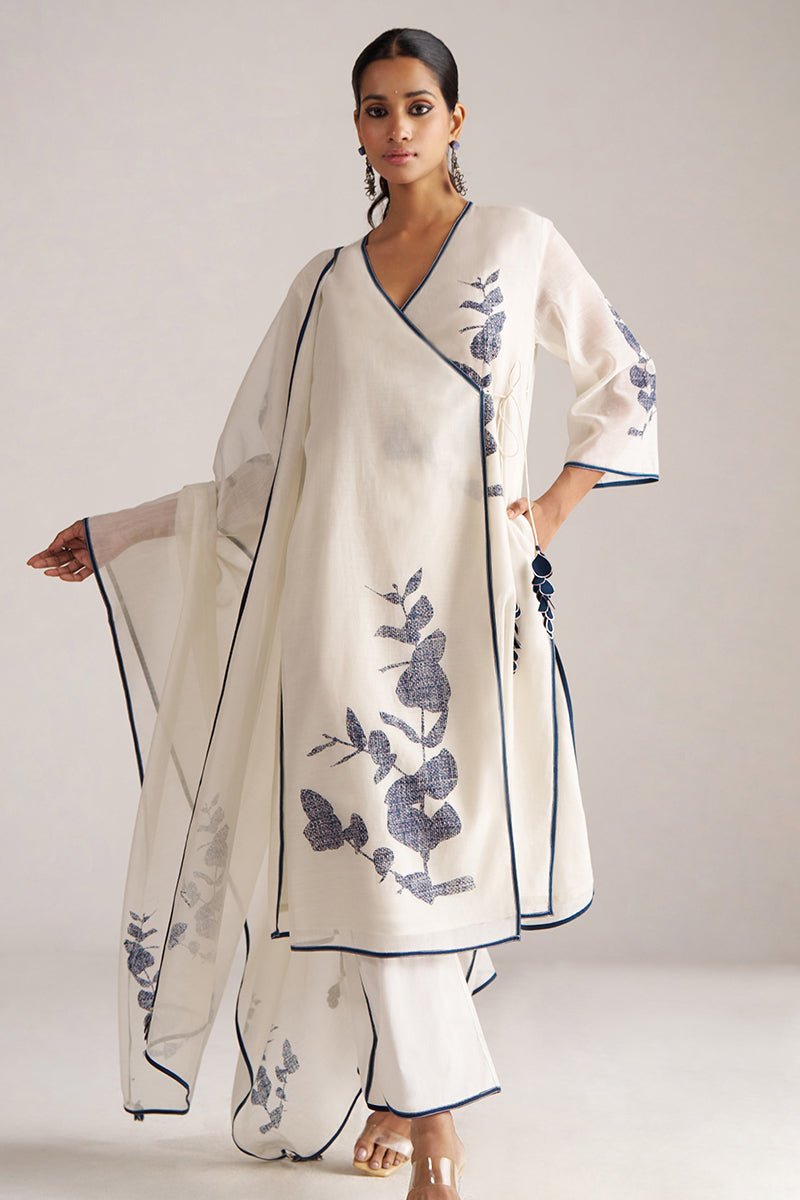 Woman wearing a white outfit with blue floral embroidery on a plain background | Ivory and Navy Blue Pure Chanderi Kurta Set
