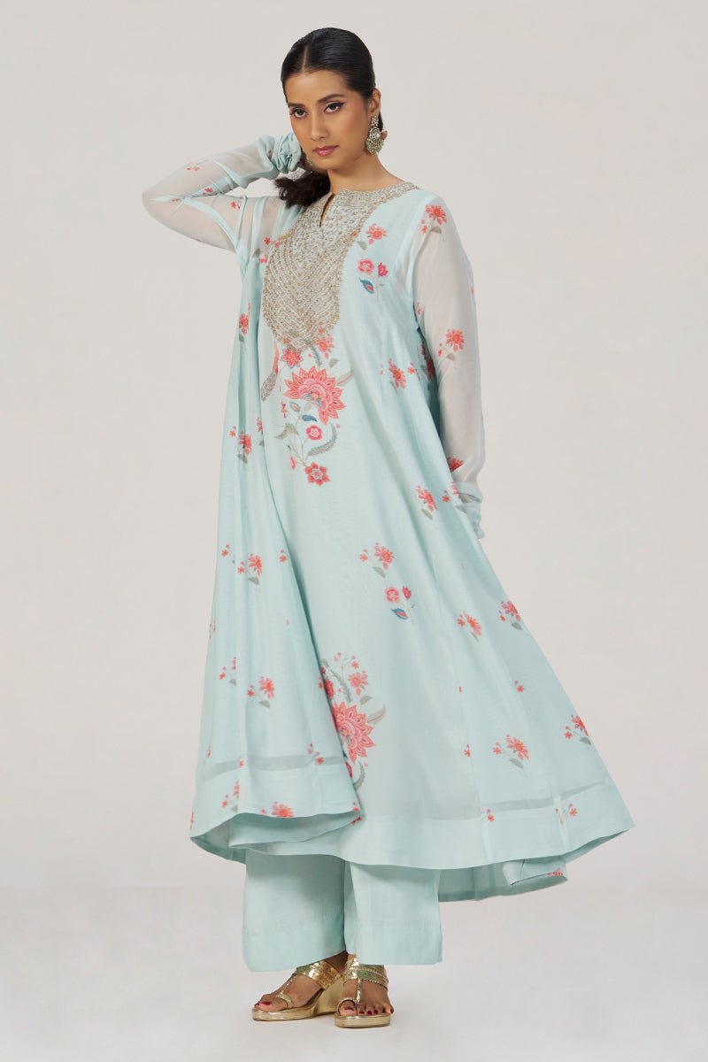 A woman models a light blue-green (mint) traditional Indian outfit consisting of a long kurta with floral embroidery, matching pants, and a sheer dupatta, set against a plain light gray studio background. | Whispering Blue Georgette Festive Kurta Set - Ganga Fashions