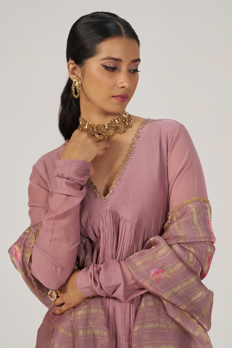 A woman wearing a dusty pink traditional outfit with gold embroidered details and a matching striped dupatta, photographed against a plain light gray studio background. | Woodrose Chanderi Silk Festive Kurta Set - Ganga Fashions