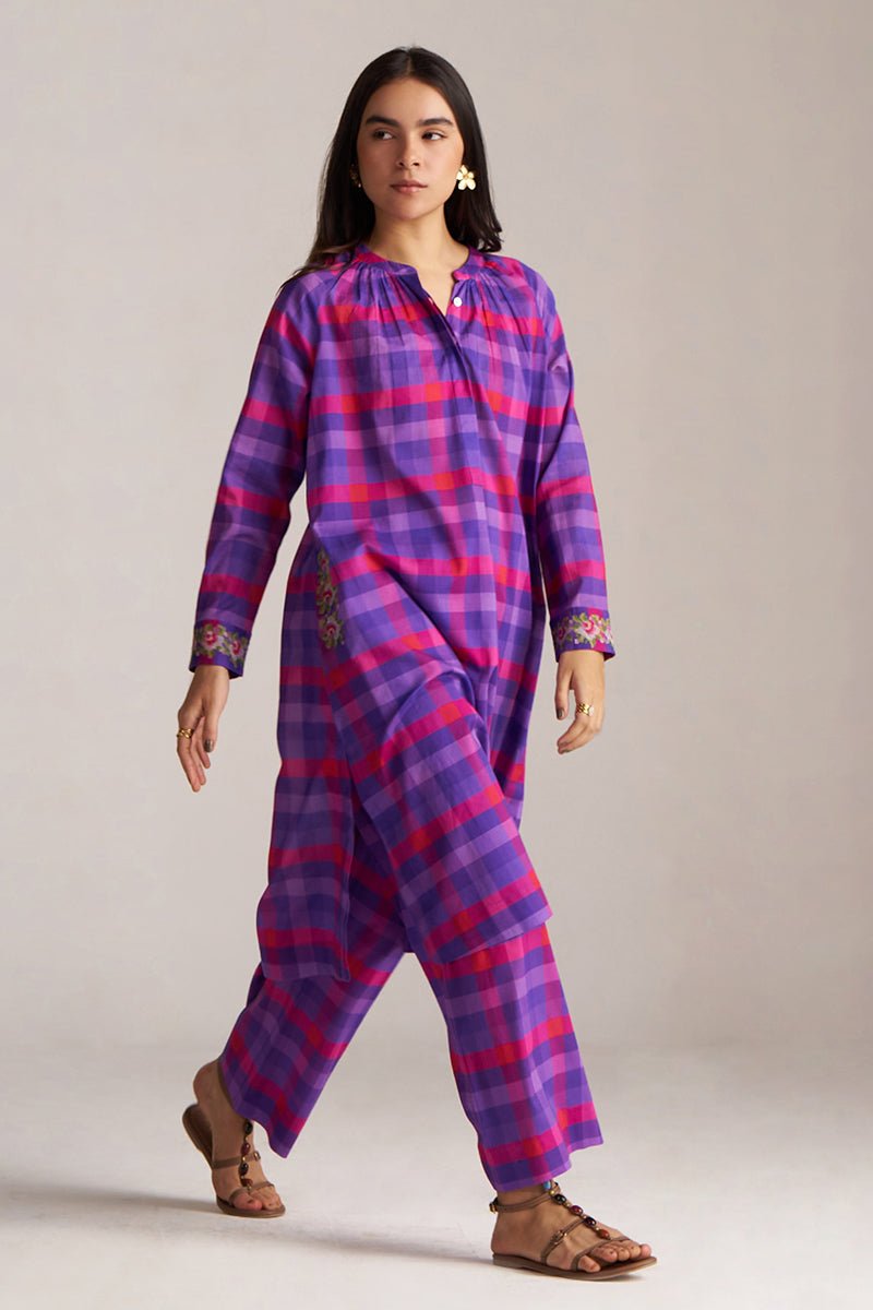 Woman wearing a purple and pink plaid outfit on a plain background | Purple Checkard Mul Mul Co Ord Set