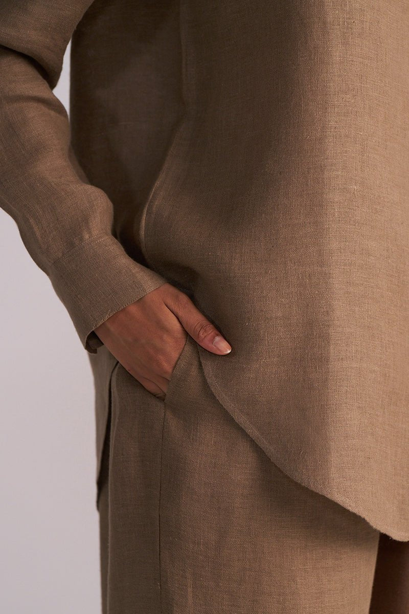 Woodsmoke Brown Pure Linen Co-ord Set with a hand in the pocket on a light gray background