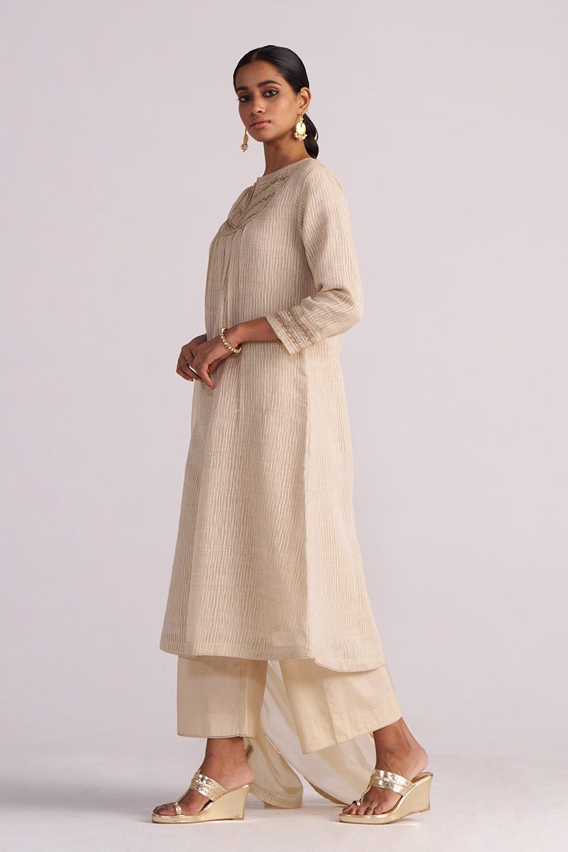 Woman wearing a Beige Woven Kurta Set on a light gray background