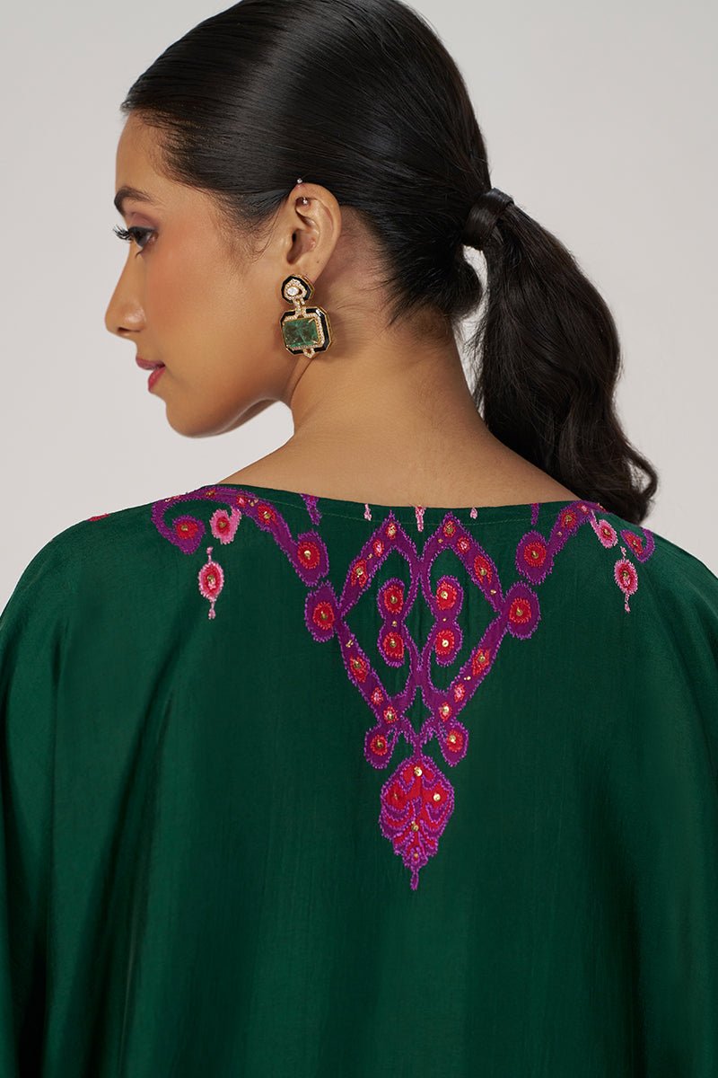 A woman shown from the back wearing a dark green kurta with a prominent magenta and orange embroidered yoke pattern, paired with green and gold earrings, against a light gray studio background. | Evergreen Silk Festive Kaftaan Set - Ganga Fashions
