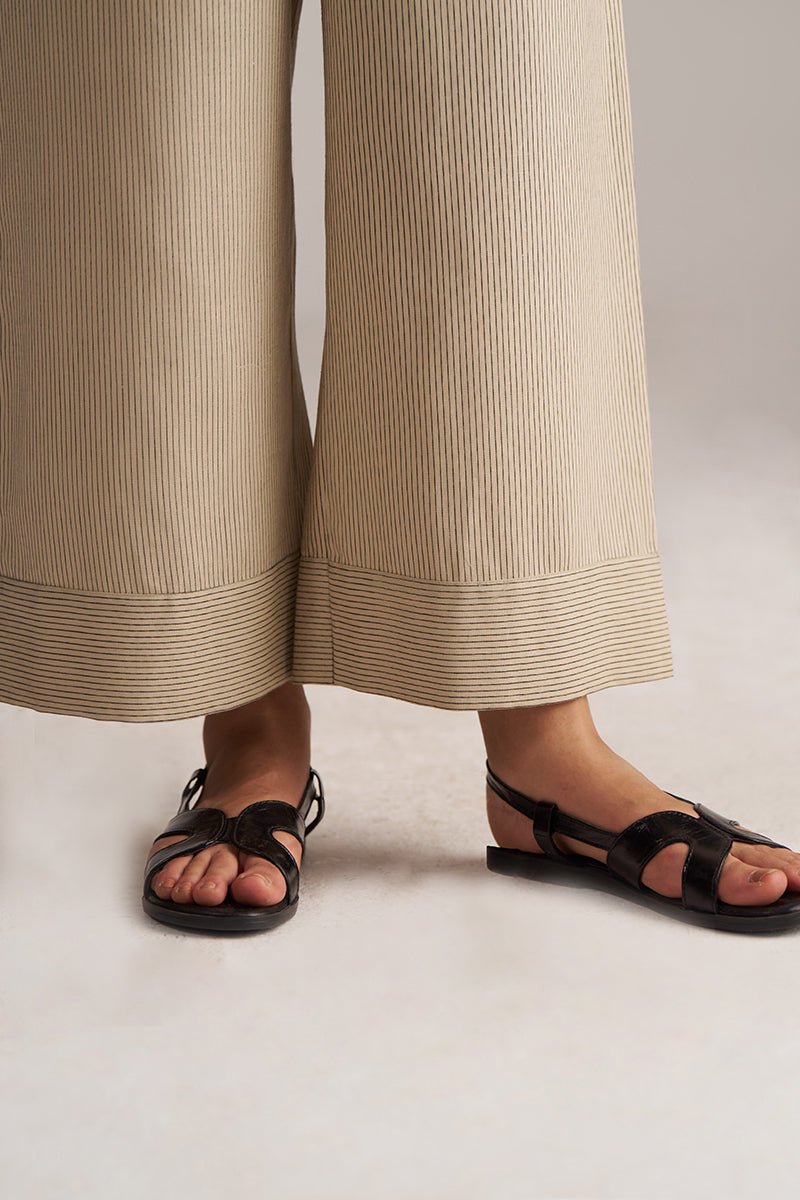 Person wearing black sandals and beige pants on a plain background | Brown Rice Co-ord Set for Women | Rangmanch | Ganga Fashions