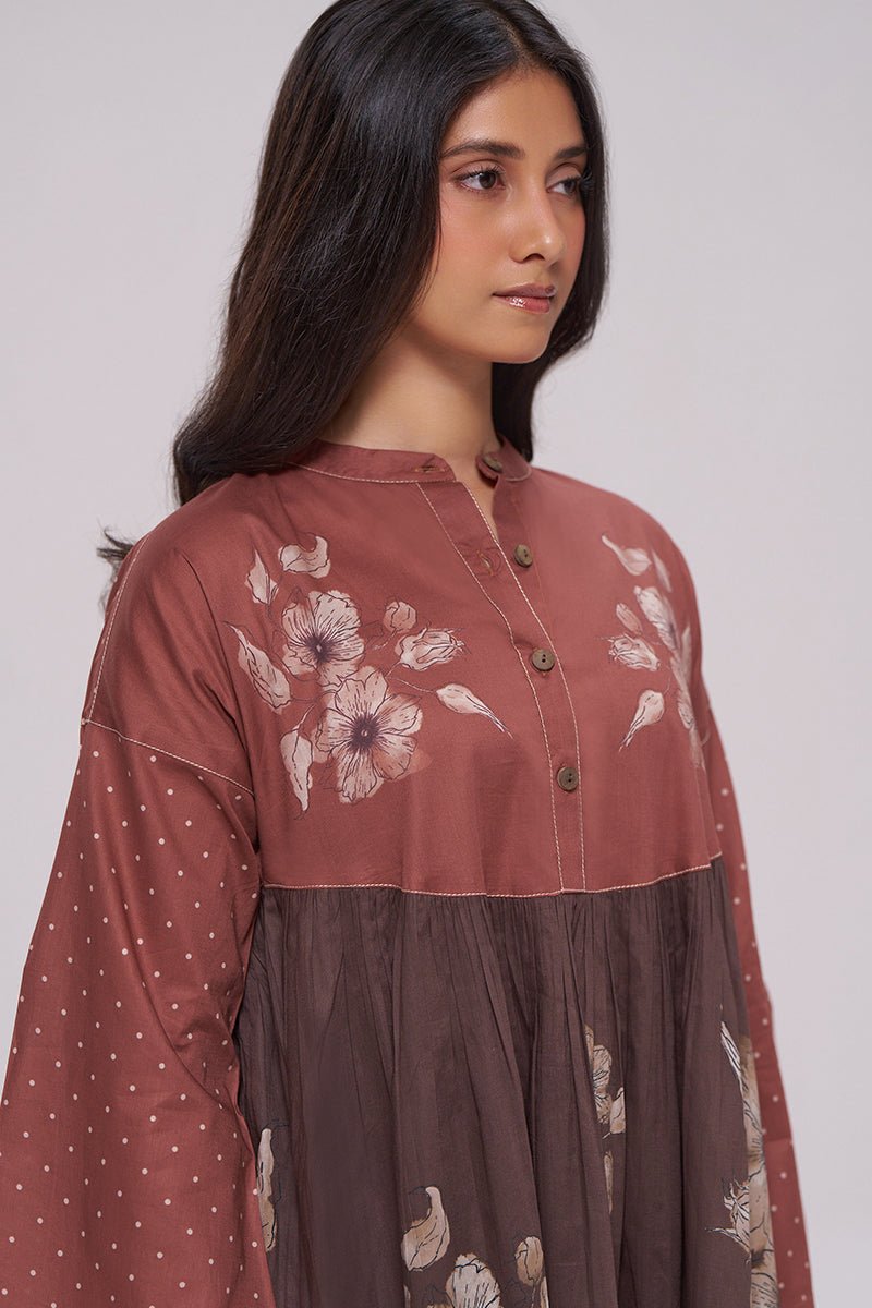 A woman wearing a long-sleeve button-front tunic dress in dusty rose and dark brown, with floral embroidery on the bodice and upper skirt, photographed against a plain light gray studio background. | Rust and Warm Cocoa Floral Kurta With Stripe Bottom Set - Ganga Fashions