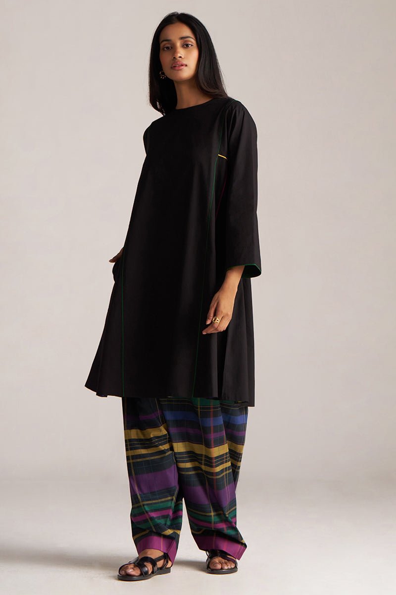Woman wearing a black long-sleeve top and colorful striped pants on a plain background | Black Multi Colour Checkard Co Ord Set