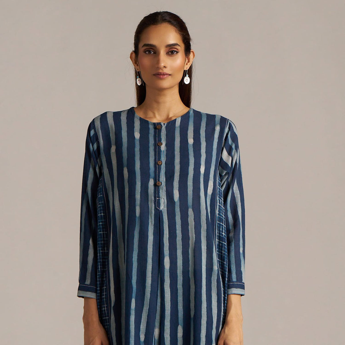 Woman wearing a blue and white striped dress against a beige background | check balance co-ord sets