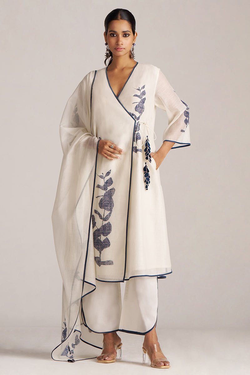Woman wearing a white outfit with floral patterns on a plain background | Ivory Navy Angrakha Chanderi Kurta Set