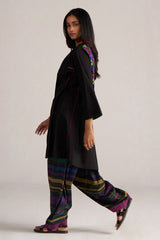 Woman wearing a black outfit with colorful embroidery and striped pants on a white background | Black Multi Colour Checkard Co Ord Set