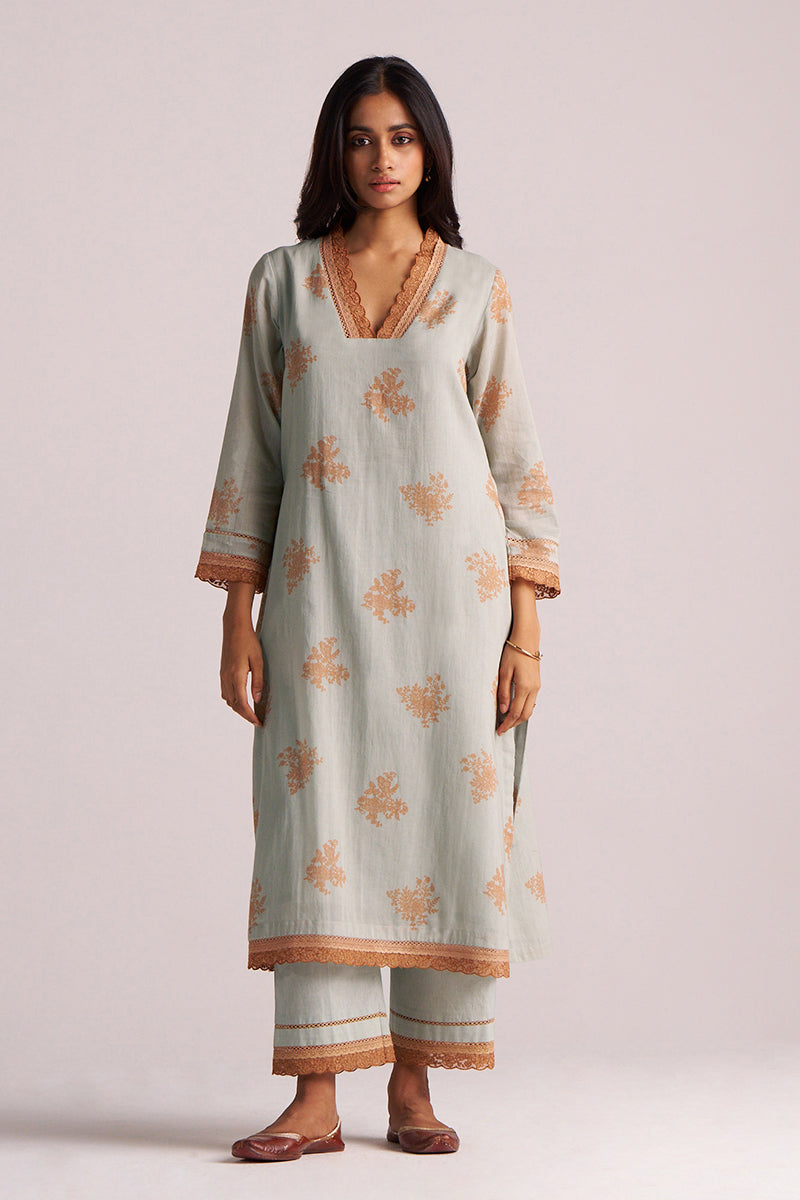 Woman wearing a Grey-Rust Mul Kurta Set with floral patterns on a plain background