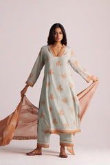 Woman wearing a Grey-Rust Mul Kurta Set with floral patterns on a plain background