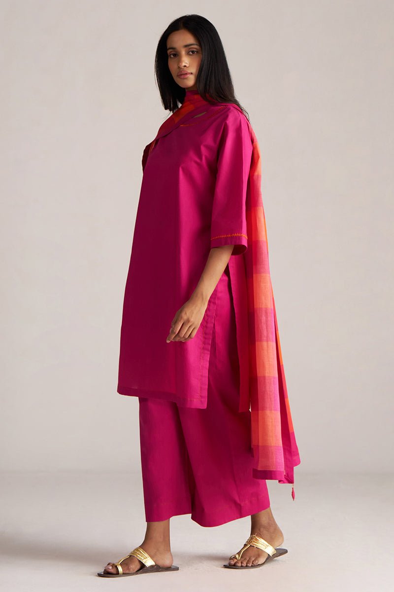 Woman wearing a bright pink traditional outfit with a colorful scarf on a plain background | Fuchsia Solid Kurta with Mul Mul Dupatta