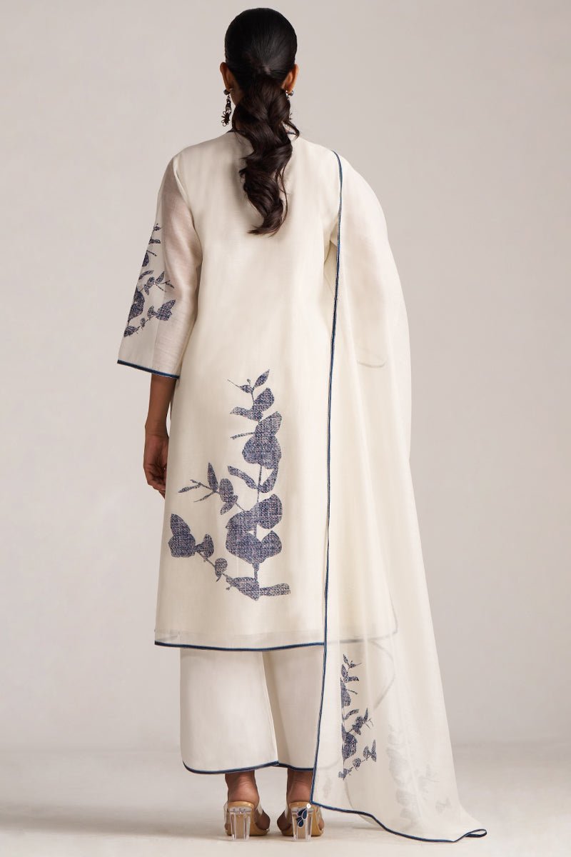 Woman wearing a white outfit with floral embroidery on a plain background | Ivory Navy Angrakha Chanderi Kurta Set

