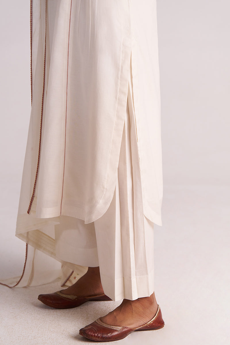 Ivory Embroidered Kurta Set with brown trim and brown shoes on a light background