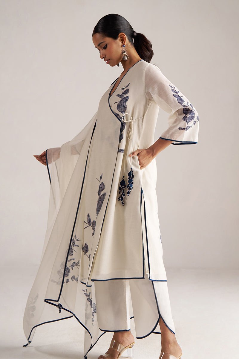Woman wearing a white outfit with floral embroidery on a plain background | Ivory and Navy Blue Pure Chanderi Kurta Set