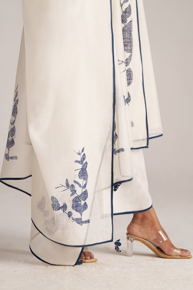 White pants with blue floral embroidery and clear high-heeled shoes on a light gray background | Ivory and Navy Blue Pure Chanderi Kurta Set