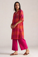 Woman wearing a red and pink checkered top with matching pants on a white background | Tomato and Fuchsia Mul Mul Co Ord Set