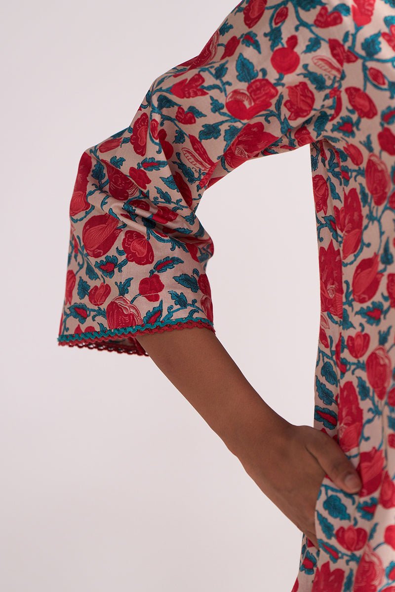 Close-up of a person wearing a Beige and Red Cotton Print Co-ord Set on a plain background.