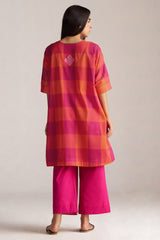 Woman wearing a red and orange checkered top with pink pants on a plain background | Tomato and Fuchsia Mul Mul Co Ord Set