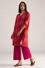 Woman wearing a red and pink checkered kurta with pink pants on a white background | Tomato and Fuchsia Mul Mul Co Ord Set