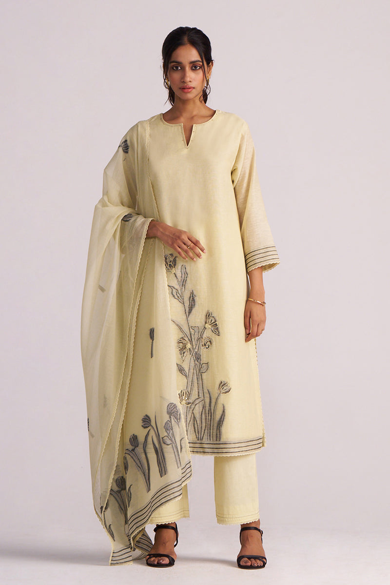 Woman wearing a Butter Yellow Chanderi Woven Kurta Set with a matching dupatta featuring black floral patterns on a white background