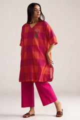 Woman wearing a red and pink checkered top with matching pants on a white background | Tomato and Fuchsia Mul Mul Co Ord Set