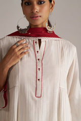Woman wearing a white blouse with red embroidery and a red scarf, against a neutral background | Buy Ivory and Maroon Pure Chanderi Kurta Set - Ganga Fashions