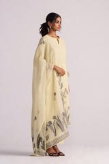 Woman wearing a Butter Yellow Chanderi Woven Kurta Set with floral patterns on a plain background