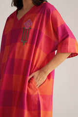 Person wearing a colorful checkered dress with a geometric design on a plain background | Tomato and Fuchsia Mul Mul Co Ord Set