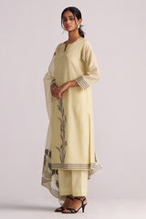 Woman wearing a Butter Yellow Chanderi Woven Kurta Set with black floral patterns on a white background