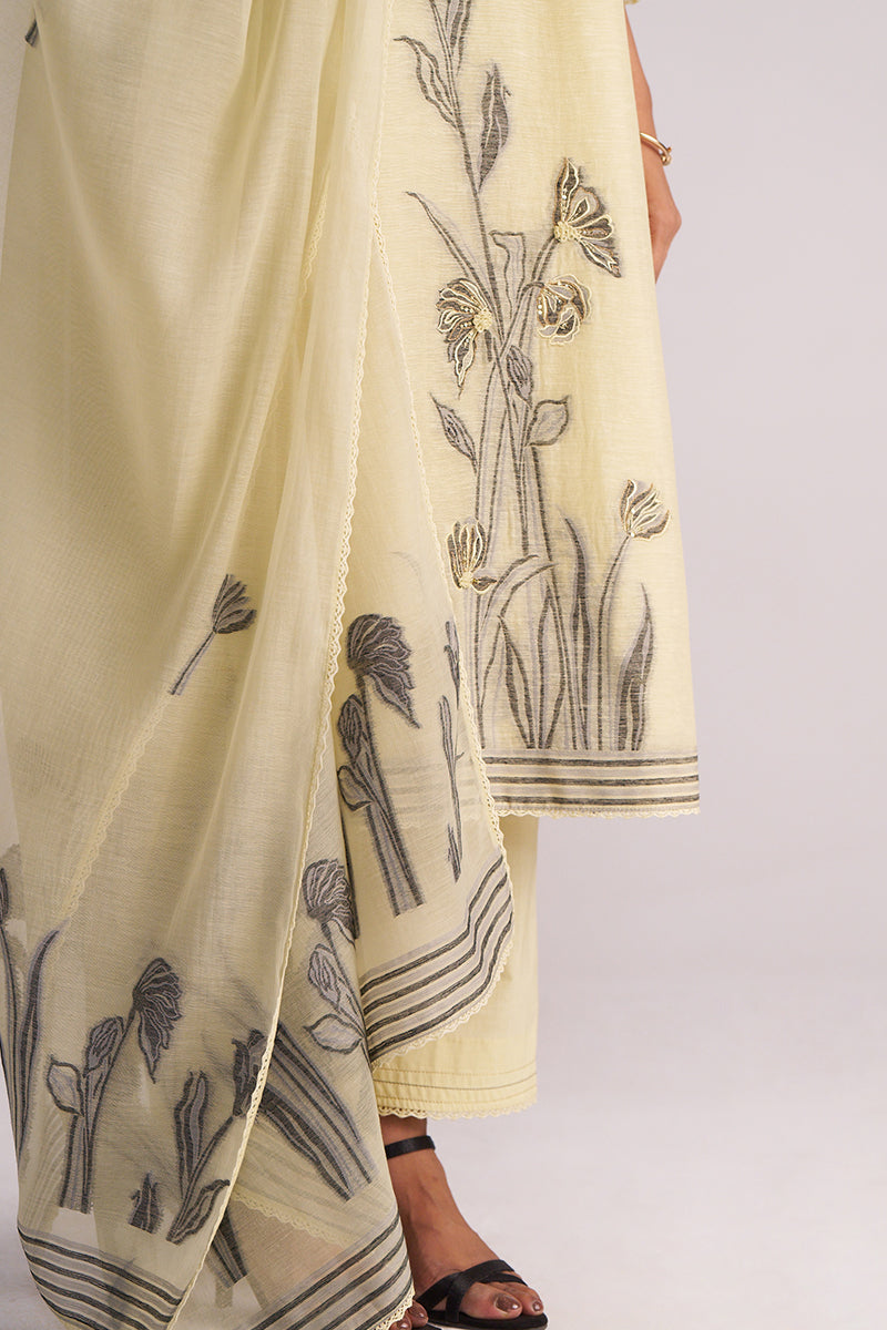 Butter Yellow Chanderi Woven Kurta Set with black floral patterns held by a person on a white background