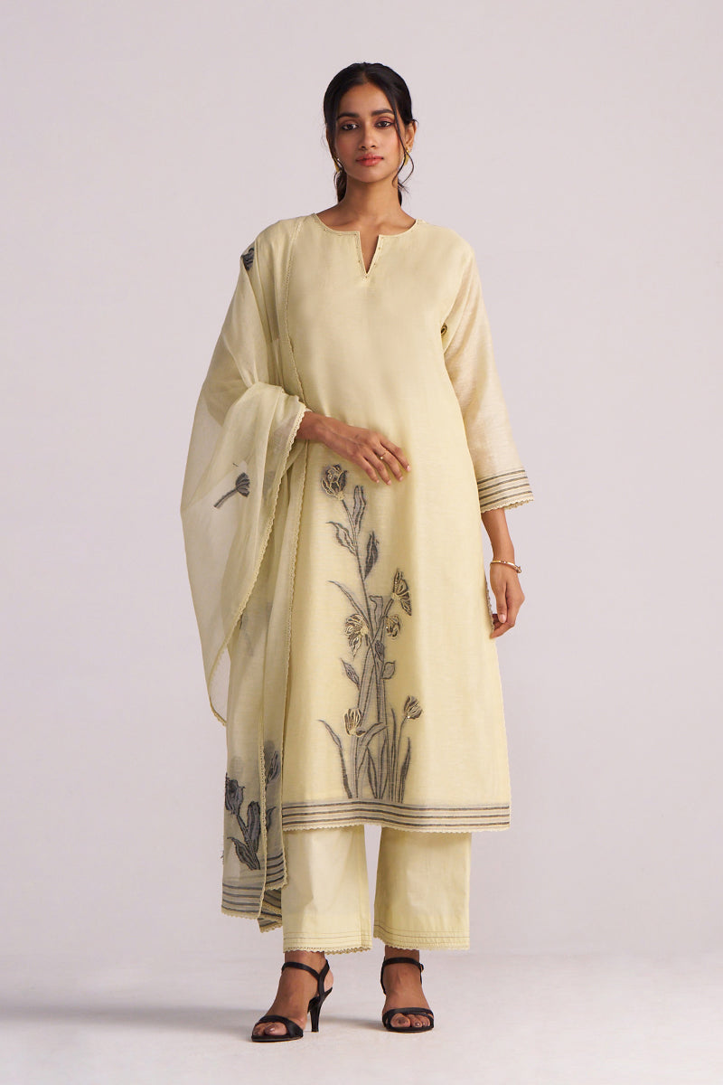 Woman wearing a Butter Yellow Chanderi Woven Kurta Set with floral patterns on a white background