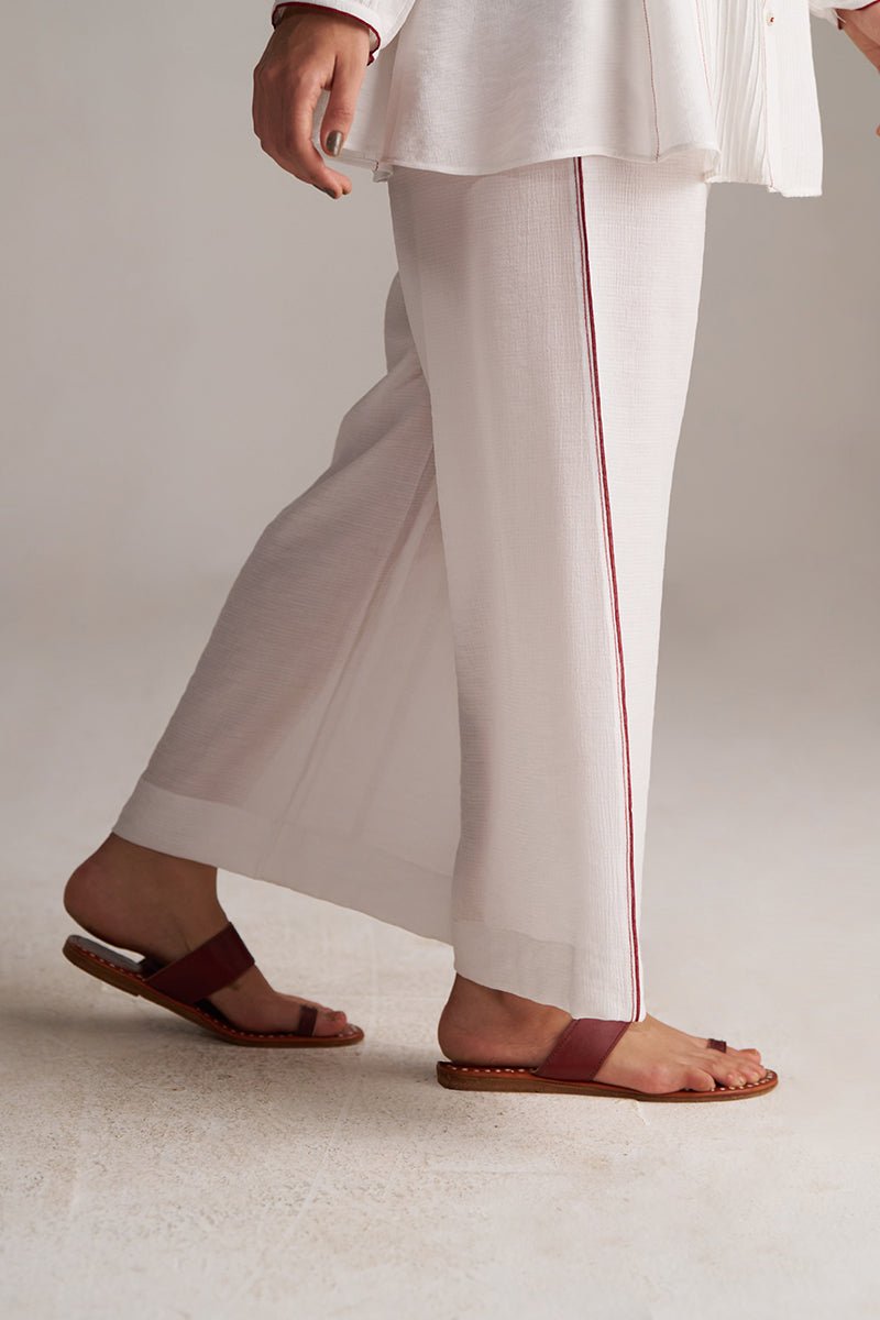 Person wearing white pants with a red stripe and brown sandals on a light background | Pure White Co-ord Set for Women | Rangmanch | Ganga Fashions