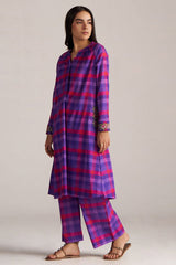 Woman wearing a purple and pink checkered traditional outfit on a plain background | Purple Checkard Mul Mul Co Ord Set