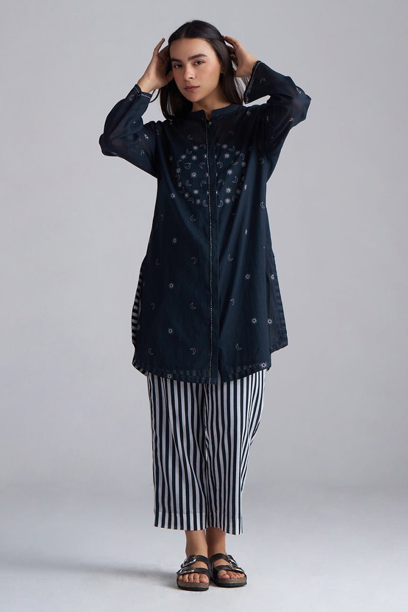 Woman wearing a dark blue jacket with star patterns and a black and white striped skirt on a gray background | Black & White Mul Mul Co-ord Set for Women | Ganga Fashions