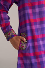 Purple and pink checkered shirt with floral embroidery on a plain background