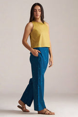 Woman wearing a yellow sleeveless top and blue pants against a plain background | Navigate Blue Checkard Kimono with Moss Yellow Top and Blue Bottom Co Ord Set