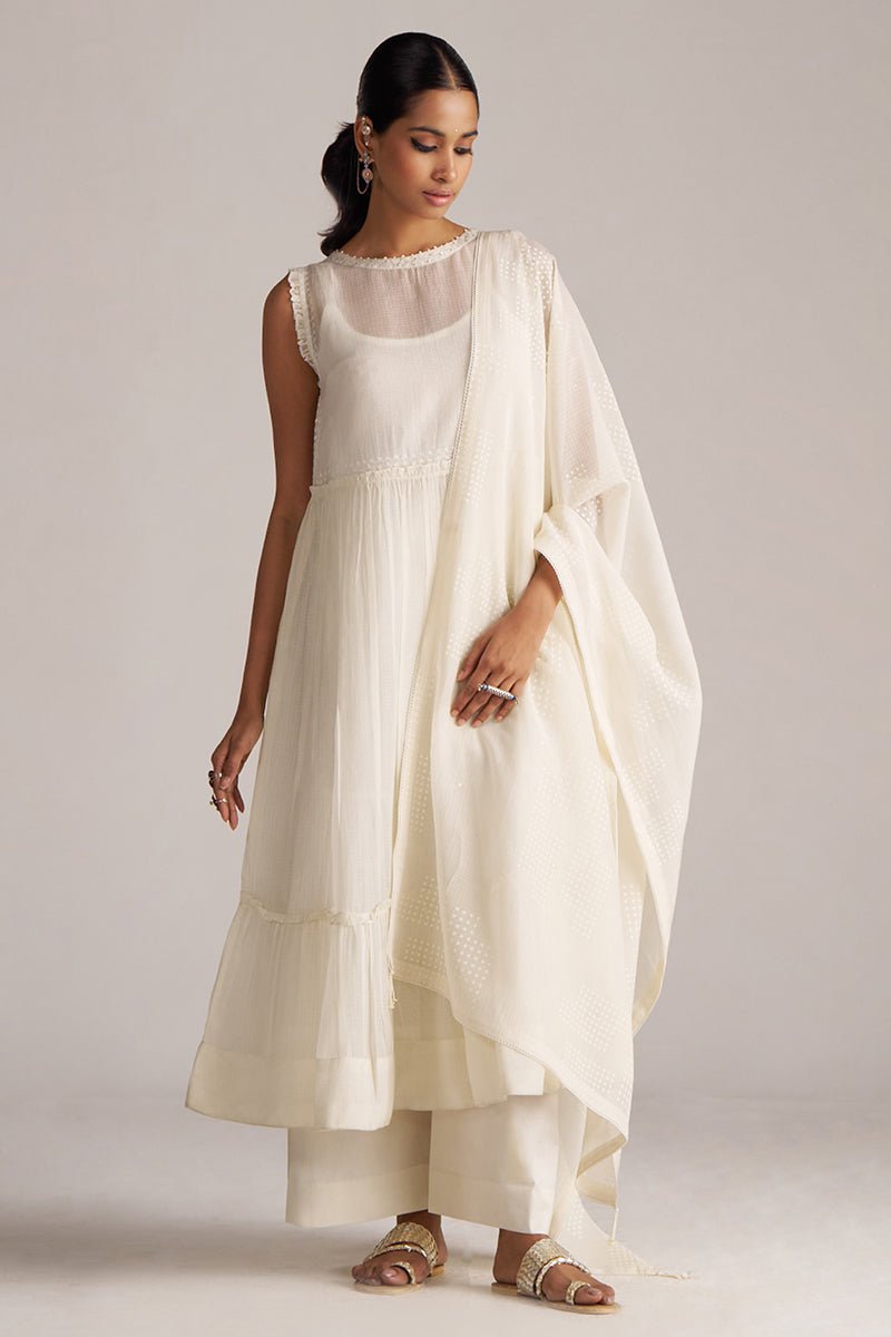 Woman wearing a white dress with a matching shawl against a plain background | Ivory Kota Silk Kurta Set for Women