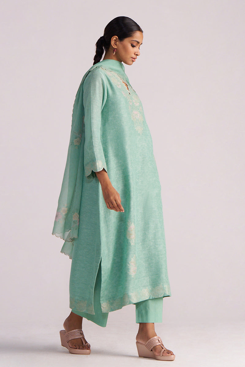 Woman wearing a Dusty Jade Green Woven Silk Kurta Set with a matching dupatta on a plain background