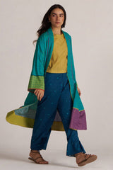Woman wearing a teal jacket and blue pants with a yellow top on a white background | Navigate Blue Checkard Kimono with Moss Yellow Top and Blue Bottom Co Ord Set