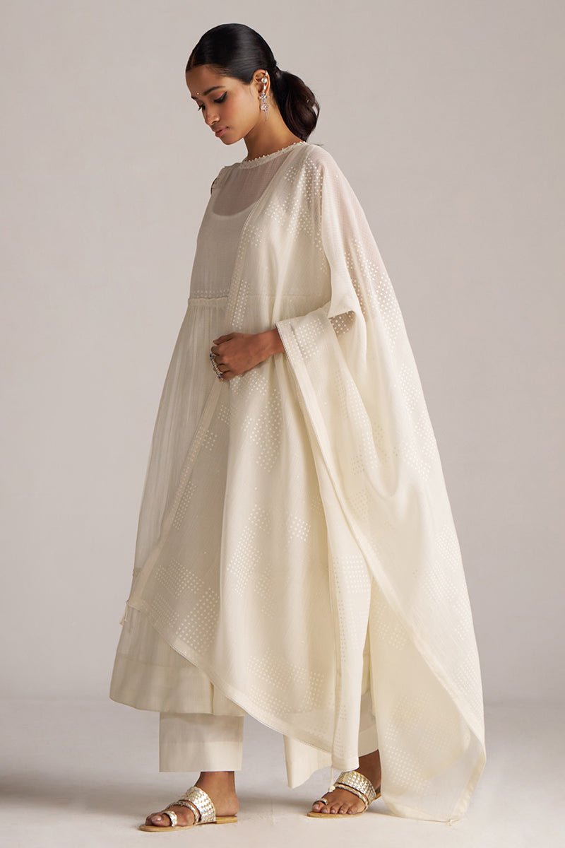 Woman wearing a cream-colored traditional outfit with a plain background | Ivory Kota Silk Kurta Set for Women