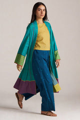 Woman wearing a teal and purple traditional outfit with a yellow top on a plain background | Navigate Blue Checkard Kimono with Moss Yellow Top and Blue Bottom Co Ord Set