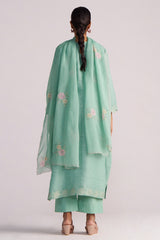 Person wearing a Dusty Jade Green Woven Silk Kurta Set with floral patterns on a plain background