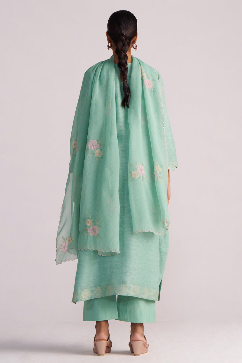 Person wearing a Dusty Jade Green Woven Silk Kurta Set with floral patterns on a plain background