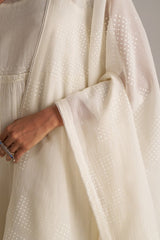 Close-up of a beige dress with a textured fabric and a hand holding a ring. | Ivory Kota Silk Kurta Set for Women