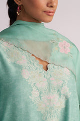 Close-up of a lDusty Jade Green Woven Silk Kurta Set with floral patterns.