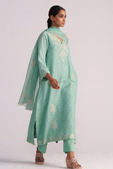 Woman wearing a Dusty Jade Green Woven Silk Kurta Set with floral patterns on a white background