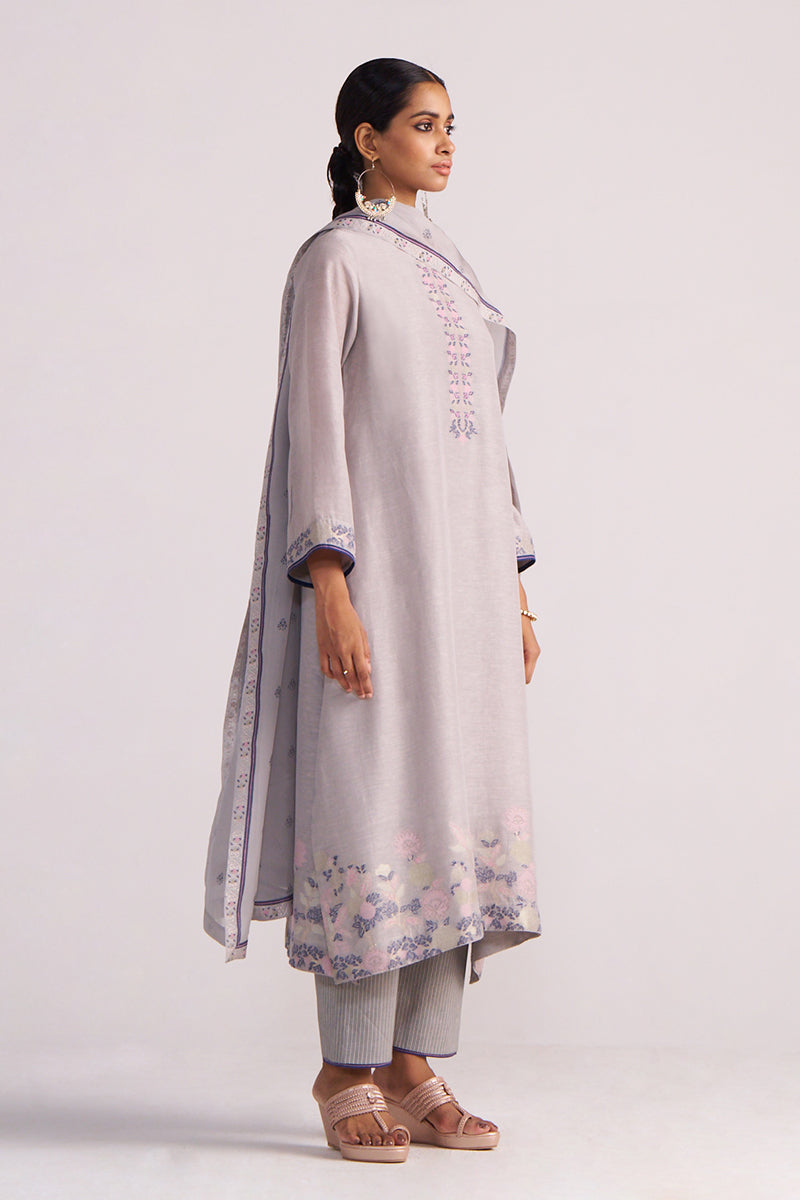 Woman wearing a Grey Woven Kurta Set with floral patterns on a white background