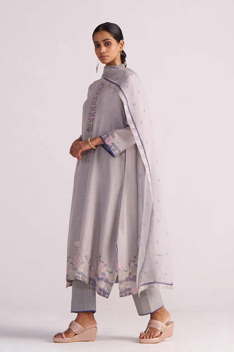 Woman wearing a Grey Woven Kurta Set with a white dupatta on a white background